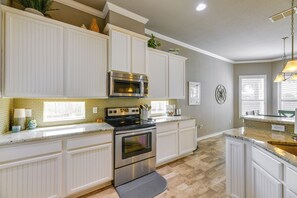 A kitchen with white cabinetry, a stainless steel oven, a microwave, and a granite countertop. - Charming Fulton Retreat < 1 Mi to Ocean & Pier! (Fulton)