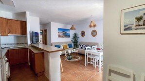 Um espaço compacto com cozinha compacta, área de refeições e sala de estar.