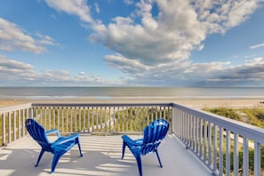 A balcony with two blue Adirondack chairs overlooking a beach. - Spacious Isle of Palms Home w/ Ocean Views! (Isle of Palms)