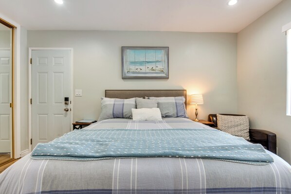 A neatly made bed with a blue and white striped bedspread, a headboard, and a framed picture of birds on the wall. - Cozy Simi Valley Studio < 10 Mi to Hiking & Golf (Simi Valley)