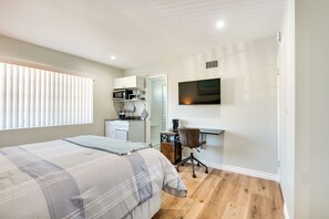 A bedroom with a bed, a desk, a chair, a TV, and a kitchenette. - Cozy Simi Valley Studio < 10 Mi to Hiking & Golf (Simi Valley)