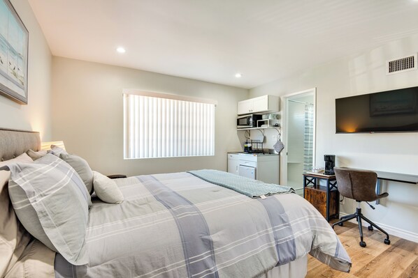 A bedroom with a bed, a desk, a chair, a TV, and a window with blinds. - Cozy Simi Valley Studio < 10 Mi to Hiking & Golf (Simi Valley)