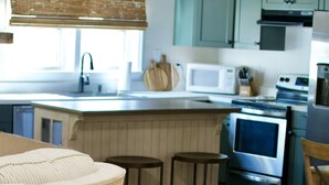 Une cuisine moderne avec des armoires de couleur turquoise, un plafond en bois et un îlot central.