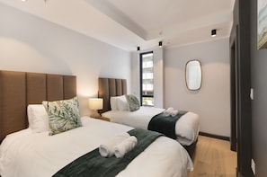 A hotel room with two beds, a large mirror, and a view of the outdoors. - Portswood 103 (Cape Town)