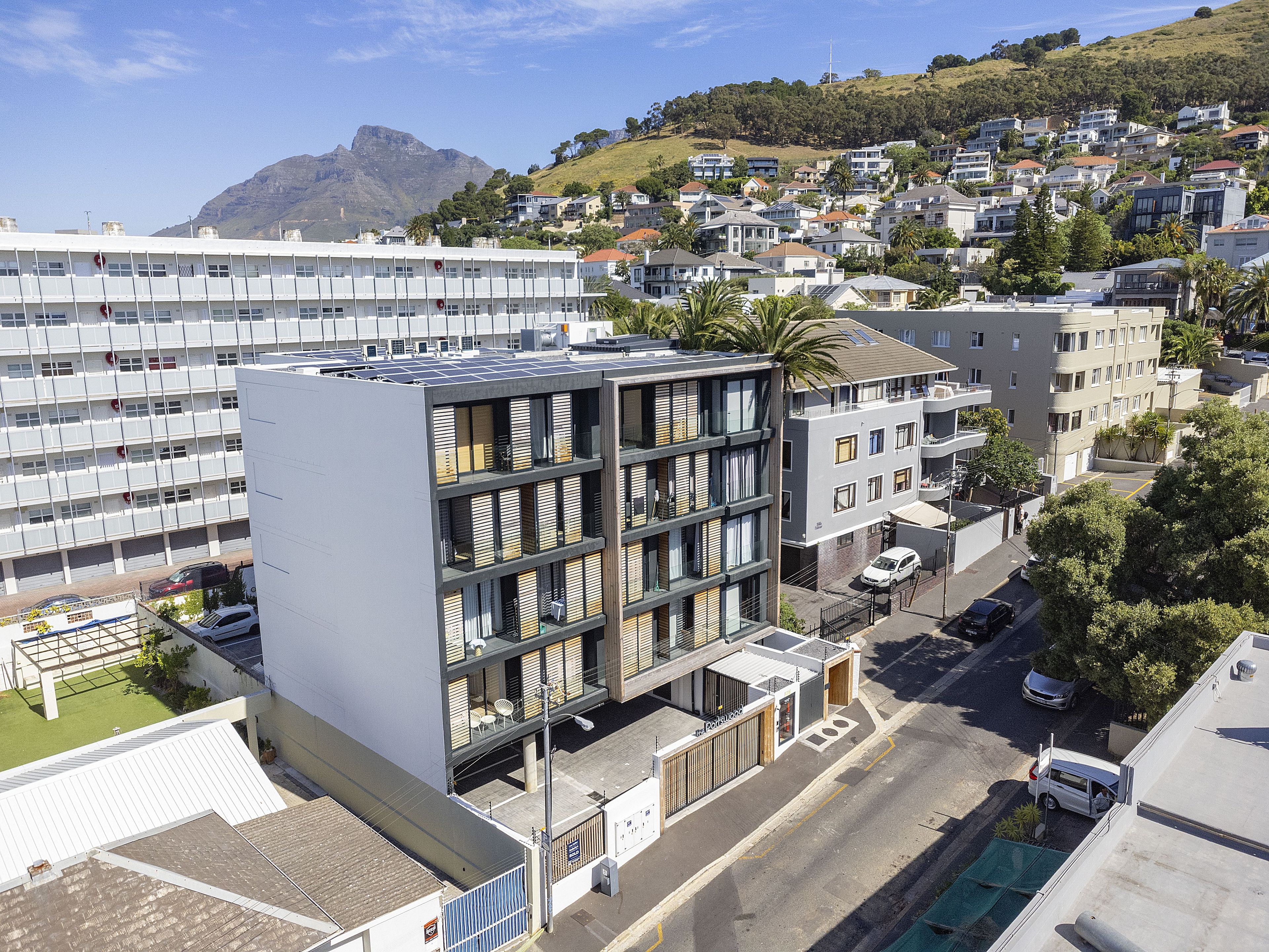 En modern byggnad med flera våningar, balkonger och en parkeringsplats.
