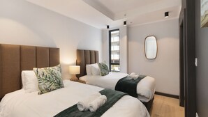 A hotel room with two beds, a large mirror, and a view of the outdoors. - Portswood 103 (Cape Town)