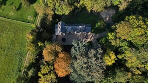 Une vue aérienne d’un bâtiment entouré d’arbres et d’un champ.