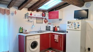 A compact kitchen with a washing machine, microwave, and a red refrigerator. - CA POMPOSA bed & relax  (Modena)