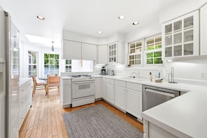 A modern kitchen with white cabinetry, a built-in oven, and a dishwasher. - Union Pier Home with Private Pool and Association Beach! (Union Pier)