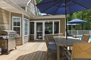 A wooden deck with a grill, outdoor table, chairs, and umbrellas. - Union Pier Home with Private Pool and Association Beach! (Union Pier)