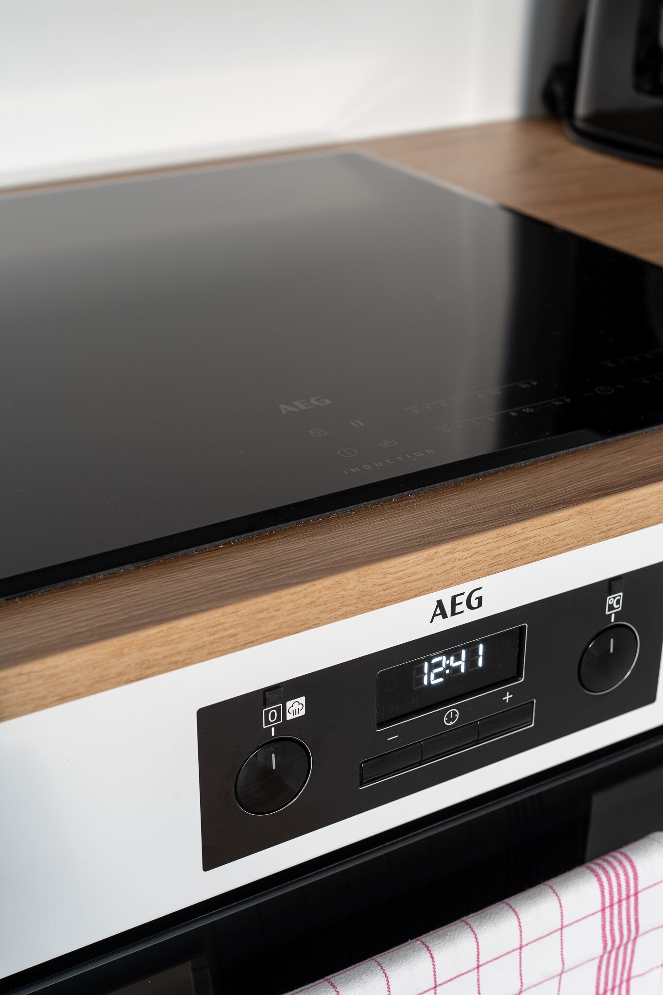 Una cocina con una placa de inducción y un reloj digital que marca las 12:41.