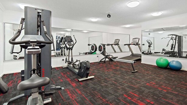 A gym with cardio machines, weight equipment, and exercise balls. - Picture Perfect On Azure (Airlie Beach)