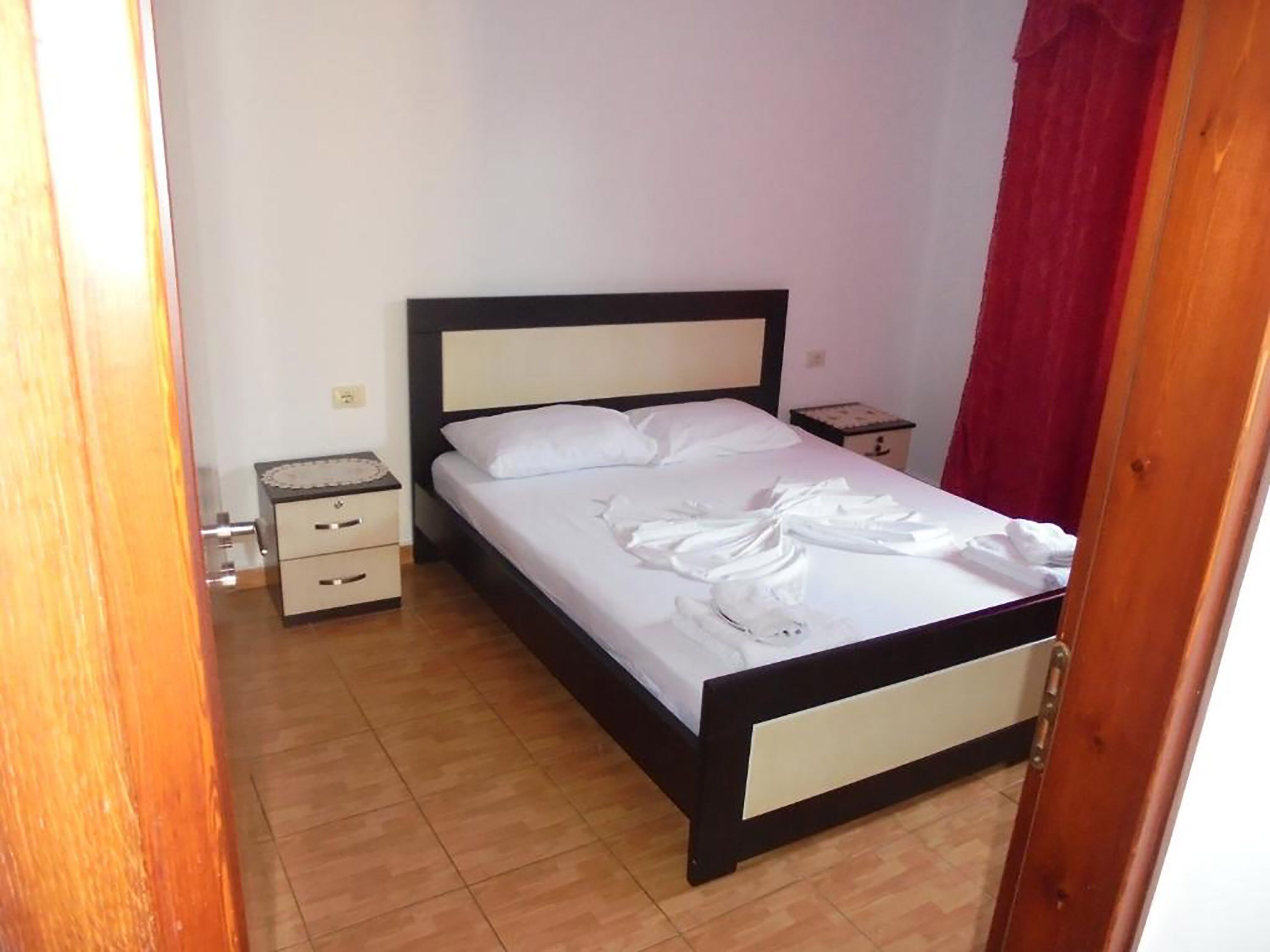 A bedroom with a bed, a nightstand, and a dresser.