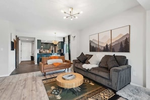 Un salon moderne avec un canapé, une table basse et un tableau au mur.