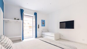 A bedroom with a bed, a wardrobe, a TV, and a balcony. - White Blue Apartment at Sanit by Wonderful Italy (Naples)