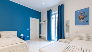 A bedroom with two beds, a wardrobe, a mirror, and a painting on the wall. - White Blue Apartment at Sanit by Wonderful Italy (Naples)