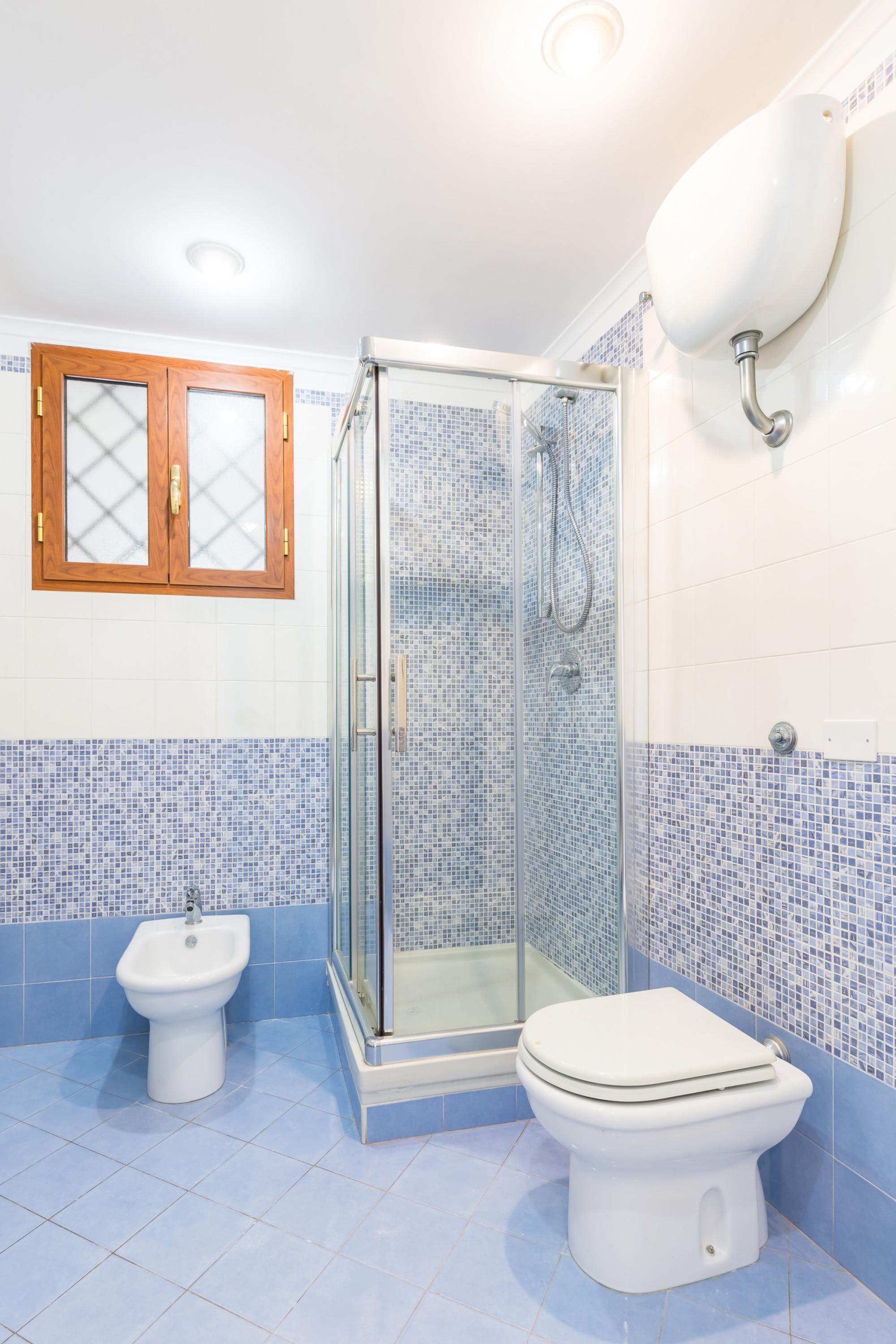 A bathroom with a shower, bidet, and toilet.