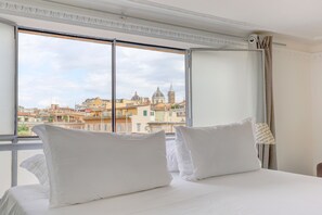 Ein Hotelzimmer mit großem Fenster und Blick auf historische Gebäude sowie eine Kuppel.