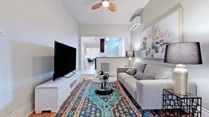 Relax in this stylish living room with a flat-screen TV, round coffee table, and comfortable sofa.