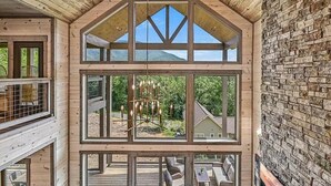 Een houten vakantiehuis met meerdere verdiepingen, grote ramen en een terras.