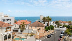 A coastal residential area with houses, a street, and a view of the ocean. - 7 on Bantry 403 (Cape Town)