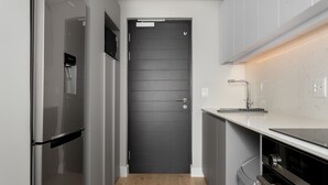 A modern kitchen with a black door, stainless steel appliances, and a marble countertop. - 7 on Bantry 403 (Cape Town)