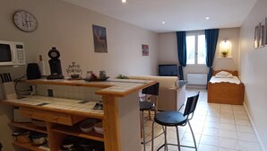 A compact kitchen with a microwave, coffee maker, and a dining table with chairs. - Grand Studio 3 Personnes Idéalement Placé (Barcelonnette)