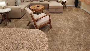 A living room with a sectional sofa, a round coffee table, a floor lamp, and a ceiling fan. - Goldie St Retreat - Heart of KDH, hot tub, pet friendly, centrally located  (Kill Devil Hills)