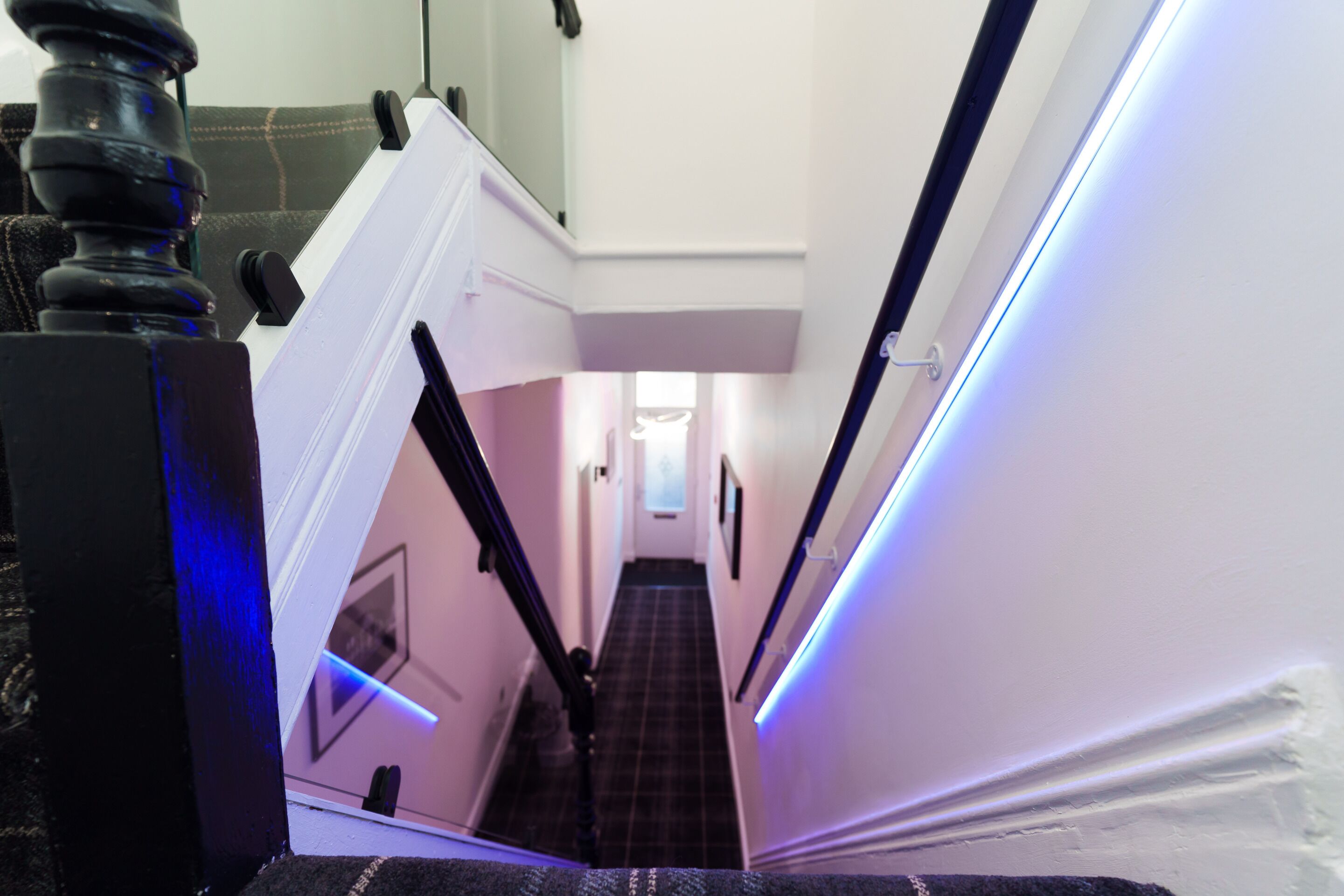 A narrow hallway with a staircase leading to an upper floor.