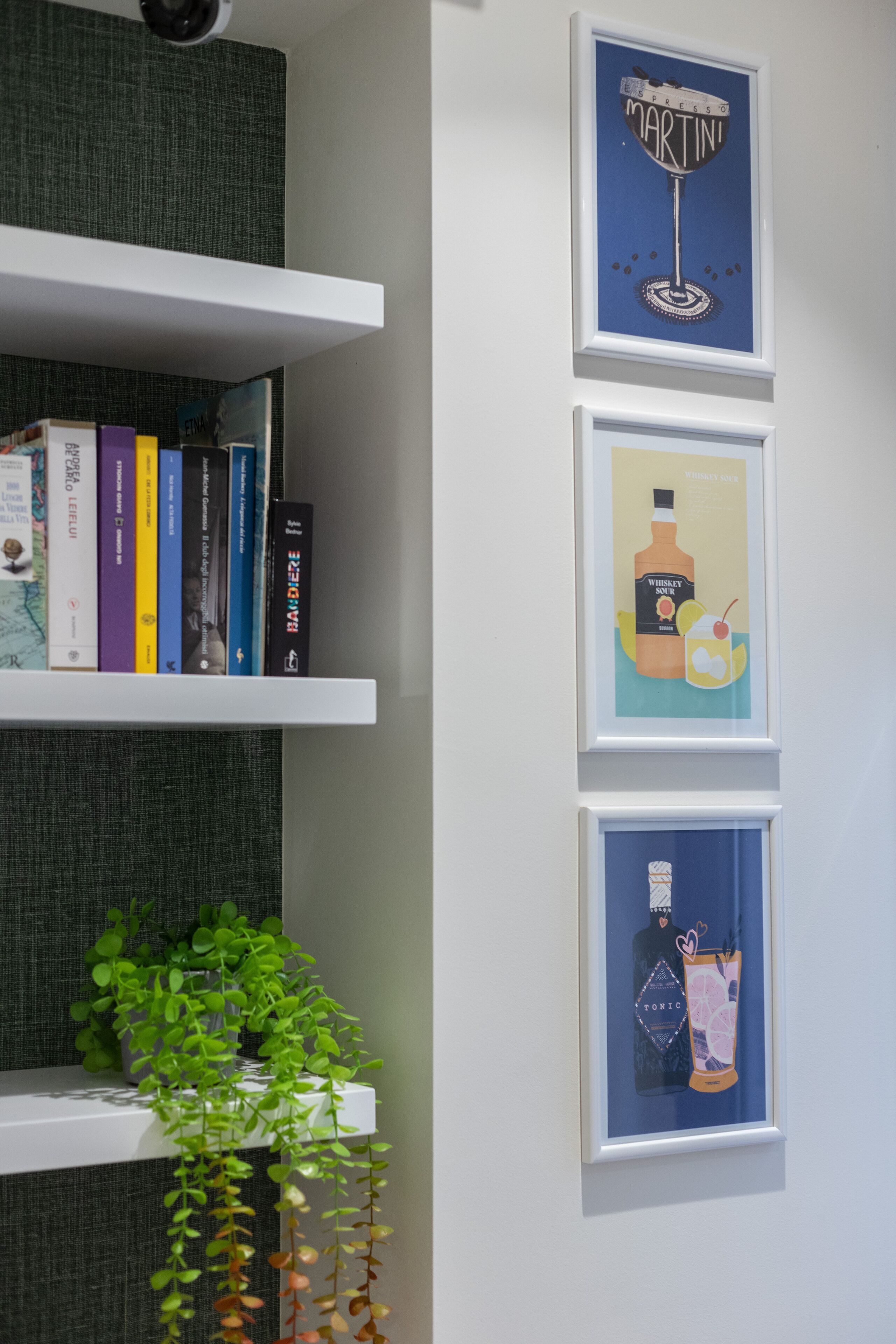 Una estantería con libros y una planta en maceta.