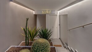 Ein moderner Flur mit einer Treppe, weißen Wänden und einem Schild mit der Aufschrift 'TAORMINA ES TOWN'.
