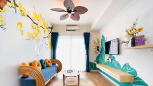 A modern living room with a sofa, a coffee table, and a TV on a wall. - HAYA SOHO SAIGON (Ho Chi Minh City)