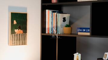 Een boekenplank met boeken, een kleine plant en een decoratief object.