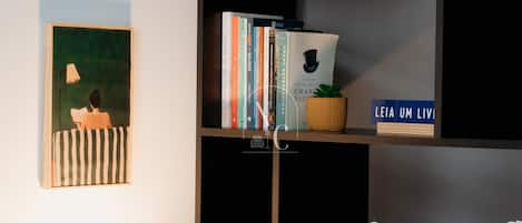 Una estantería con libros, una planta pequeña y un objeto decorativo.