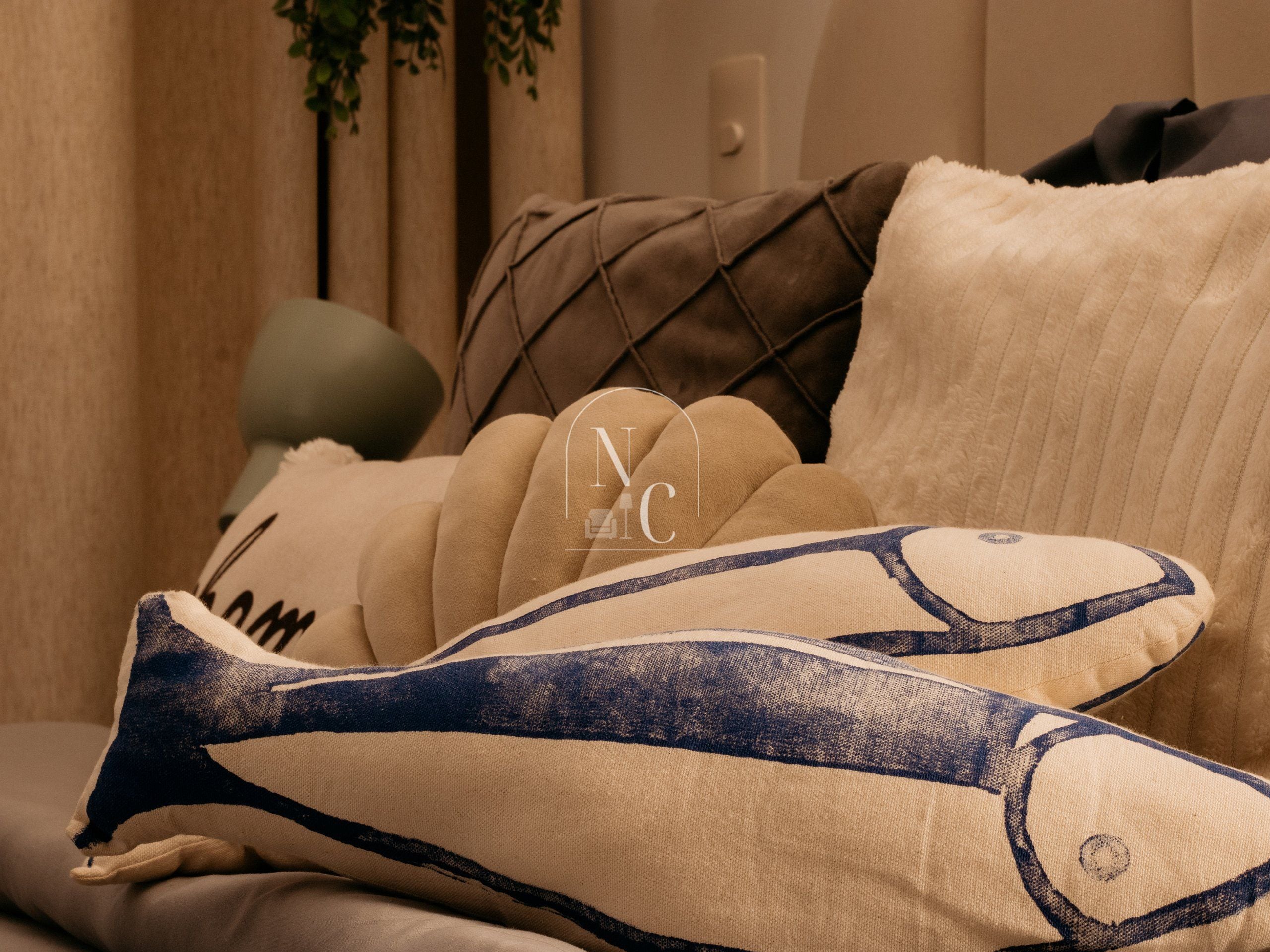 A sofa with a cushion featuring a geometric pattern and a logo.