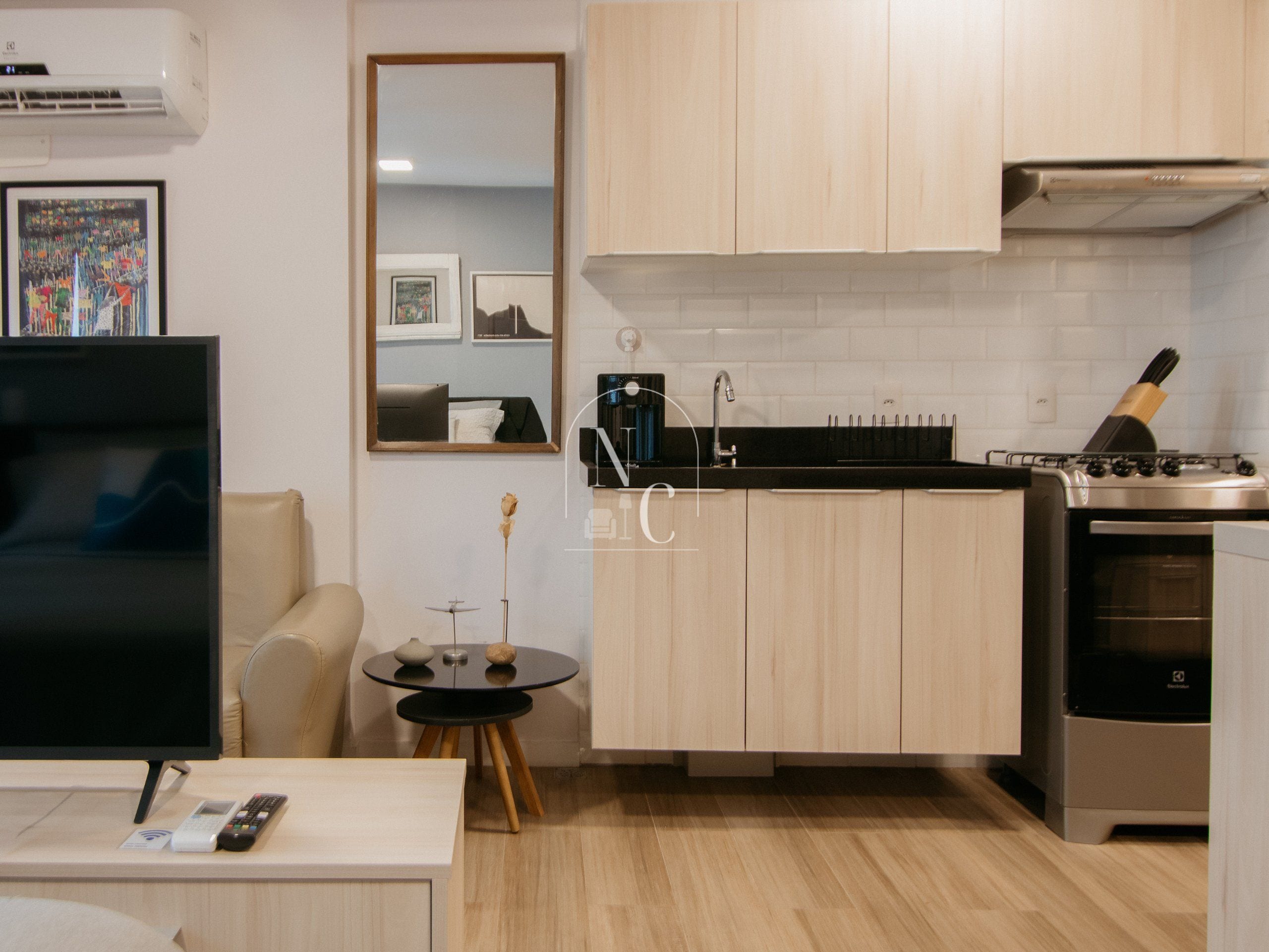 A modern kitchen with a built-in stove, a sink, and a dining area with a table and chairs.