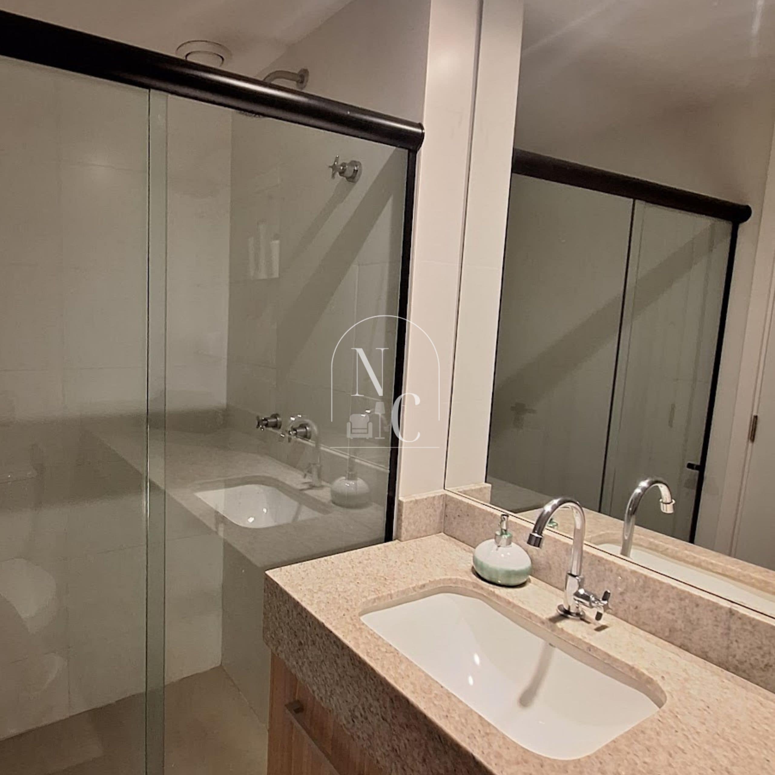 A modern bathroom with a glass shower enclosure, a sink with a mirror, and a towel rack.
