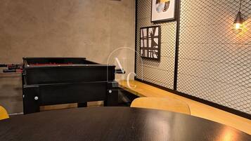 Una habitación con mesa de billar, piano y mesa redonda.