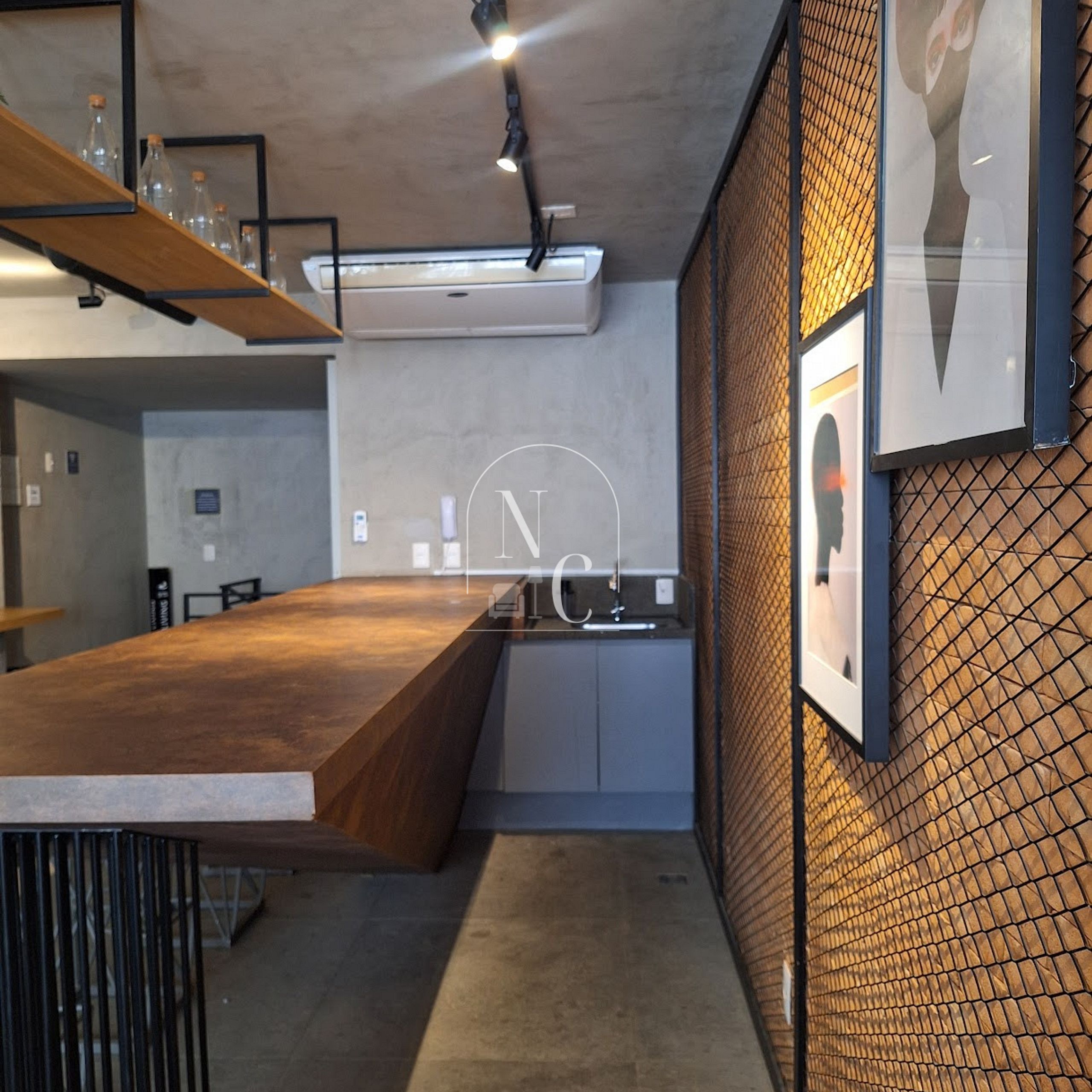 A modern kitchen with a wooden countertop, a built-in oven, and a mesh wall.