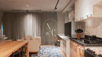 Una cocina moderna con zona de comedor, sofá y alfombra estampada.