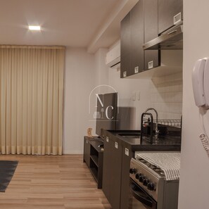 Business studio | Privékeuken | Een koelkast met diepvriezer, kookgerei, borden en bestek