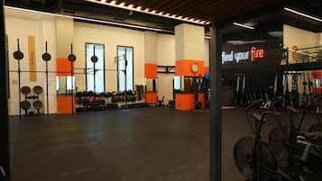 Un gimnasio con equipo de ejercicio, estantes para pesas y un letrero que dice 'find your fire'.