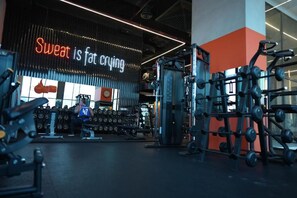 A gym with weightlifting equipment and a motivational sign. - Garden Hotel (Jabriya)