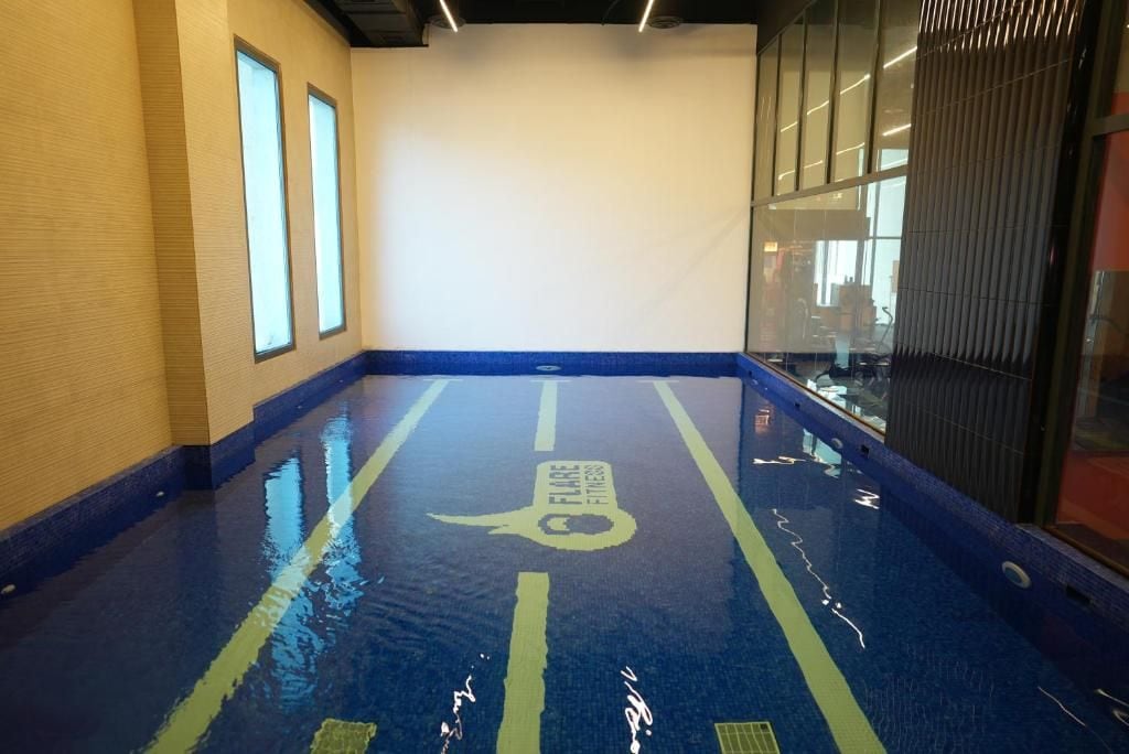Una piscina interior con marcas para carriles y un logotipo en el suelo.