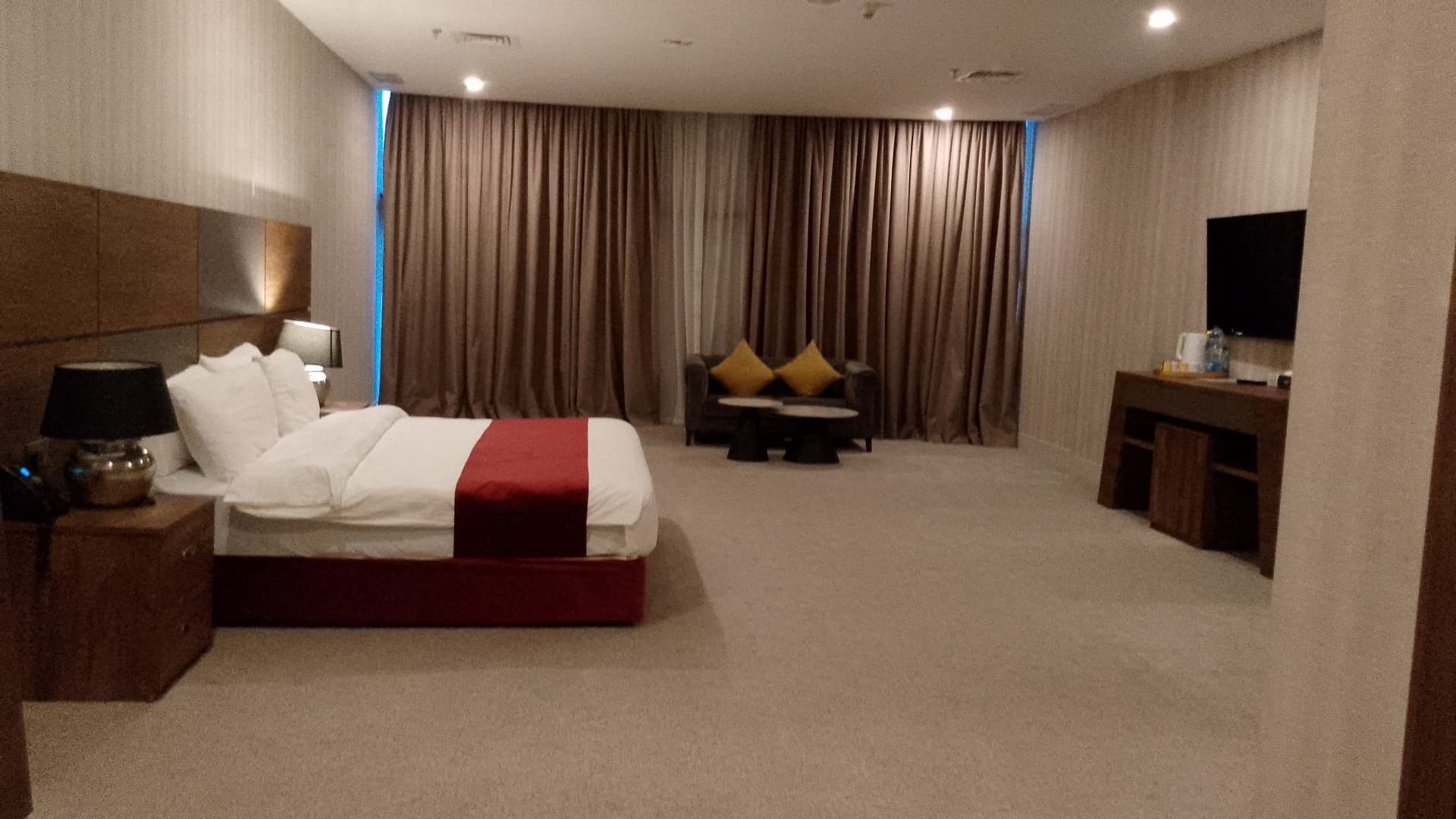Una habitación de hotel con cama, escritorio, silla y televisor.