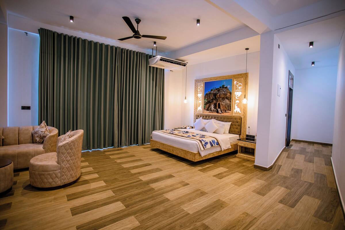 A modern bedroom with a bed, a chair, a ceiling fan, and an air conditioning unit.