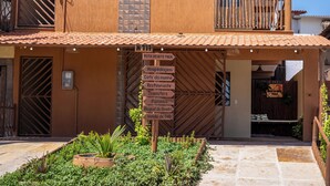 A two-story building with a sign indicating "ROTA DO KITE PREA" and various amenities listed below.