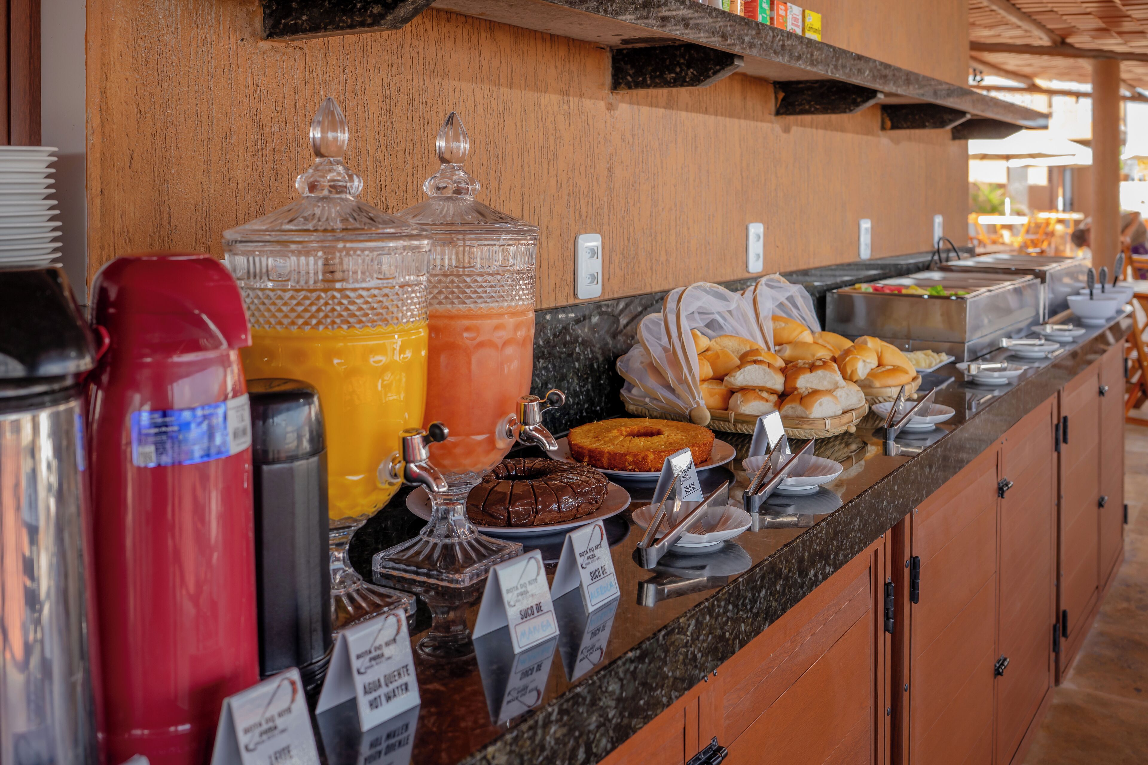A buffet counter with various food items and beverages.