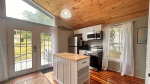 Una cocina con suelos y techo de madera, y vistas al exterior.