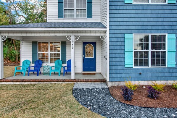 A two-story house with a porch, numbered 20, featuring blue shutters and a blue door. - North Tybee Beach Home, Near the Beach, Restaurants, Shops and More! Heated Pool Access (Tybee Island)